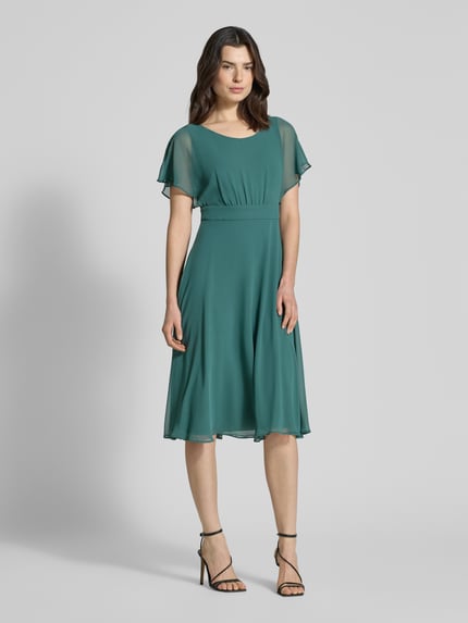 Vrouwenmodel draagt Knielanges Kleid mit Rundhalsausschnitt van Vera Mont in semi-transparant design, getailleerde fit, korte mouwen, ondoorzichtige onderjurk, ritssluiting, groene kleur, voorkant volledig zichtbaar, frontale volledige lichaamsopname.