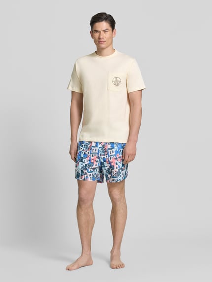 Männermodel trägt T-Shirt mit Brusttasche und Stitching Modell 'Ilfracombe' von BOARDIES, Reine Baumwolle, Regular-Fit, Rundhalsausschnitt, Brusttasche, Rückenlänge bei Größe M 71 cm, helle Farbe, strukturierte Oberfläche, Ganzkörperansicht von vorne.