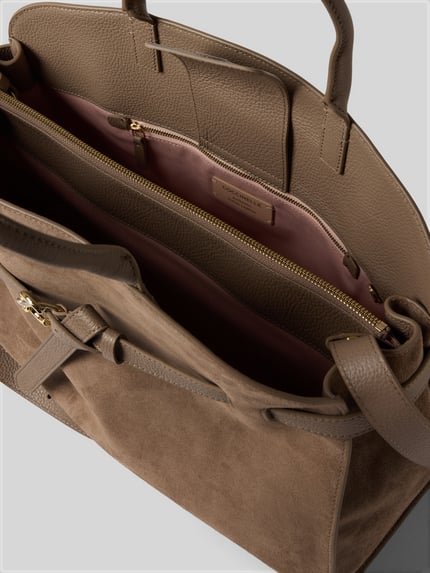 Produktfoto, Handtasche mit Logo-Detail Modell 'Sabine' von Coccinelle aus braunem Leder und Velours, Innenfach mit Reißverschluss, geteiltes Hauptfach, rosafarbenes Futter, Magnetverschluss, verstellbarer Schulterriemen, rechteckige Form, glatte und strukturierte Texturen, Kontext: Damen Handtasche von Coccinelle, Maße 44 x 32 x 16 cm, Schulterriemen 106 cm.