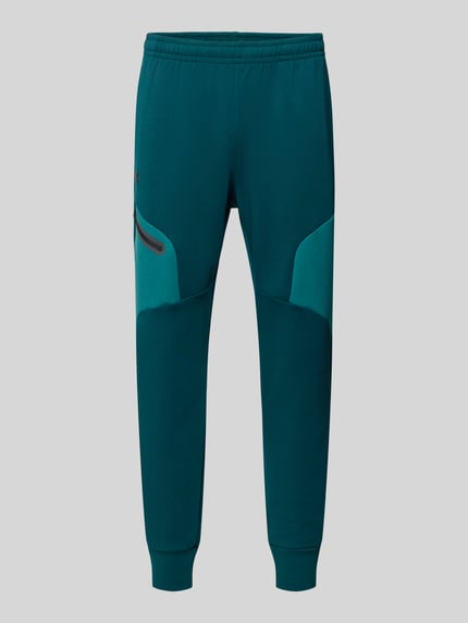 Produktfoto, Regular Fit Sweatpants mit Logo-Print Modell 'Unstoppable' von Under Armour, elastyczna mieszanka materiałów z domieszką bawełny, krój regular fit, kieszeń na nogawce z zamkiem błyskawicznym, elastyczny pas i zakończenia nogawek, długość wewnętrzna nogawki w rozmiarze M: 73 cm
