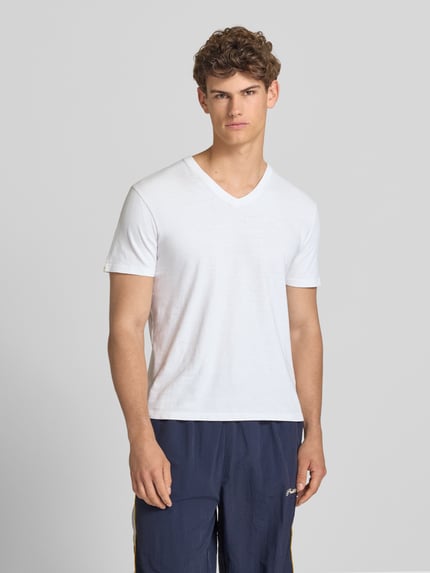 Männermodel trägt T-Shirt aus Baumwoll-Leinen-Mix mit V-Ausschnitt von Superdry in Weiß, Regular-Fit, sichtbares Stitching, Rückenlänge 68 cm, Nahaufnahme Oberkörper.
