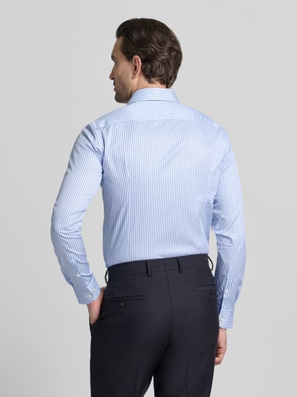 Männermodel trägt blauw-wit gestreept Slim Fit Businesshemd aus reiner Baumwolle Modell 'HANK' von BOSS, ganzlichaanzicht achterkant.