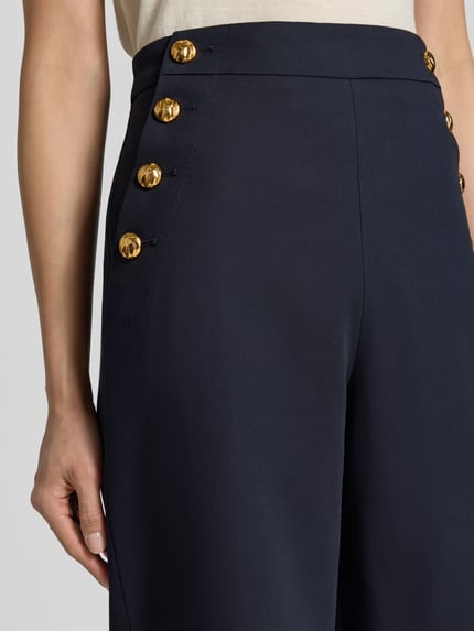 Frauenmodel trägt Weite Hose aus reiner Baumwolle Modell 'BETULLA' von Max Mara, dunkelblau mit goldfarbenen Knöpfen, Nahaufnahme Oberkörper, Damen Weite Hose von Max Mara Studio.