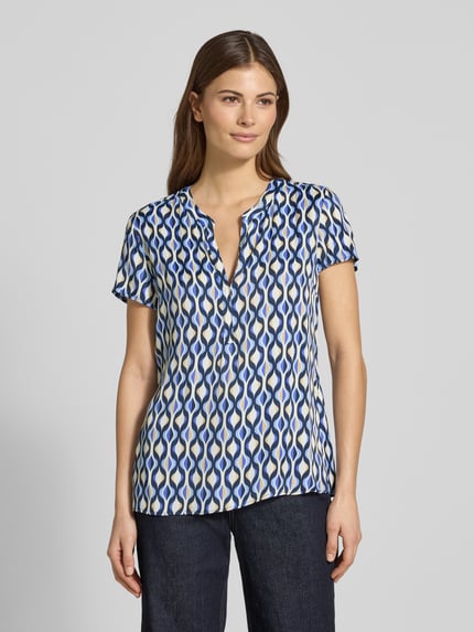 Vrouwenmodel draagt Blusenshirt aus Viskose im Allover-Look van Betty Barclay, zuiver viscose, regular fit, all-over look, V-hals, ruglengte maat 36: 61 cm, mouwlengte maat 36: 16 cm, veelkleurige golvende patronen, gladde textuur. Vooraanzicht bovenlichaam.