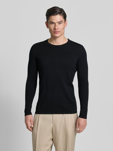 Männermodel trägt Slim Fit Pullover in Strick-Optik Modell 'Mino' von Drykorn in Schwarz, Rundhalsausschnitt, Ganzkörperansicht von vorne, reine Baumwolle