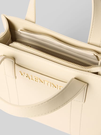 Produktfoto, Torebka z detalem z logo model 'AURY' od VALENTINO BAGS, główna przegroda z zamkiem błyskawicznym, uchwyt, pasek na ramię, przegródka wewnętrzna zapinana na zamek błyskawiczny, kolor jasny beż, faktura gładka, szerokość 25 cm, długość 22 cm, głębokość 9 cm, długość paska na ramię 135 cm