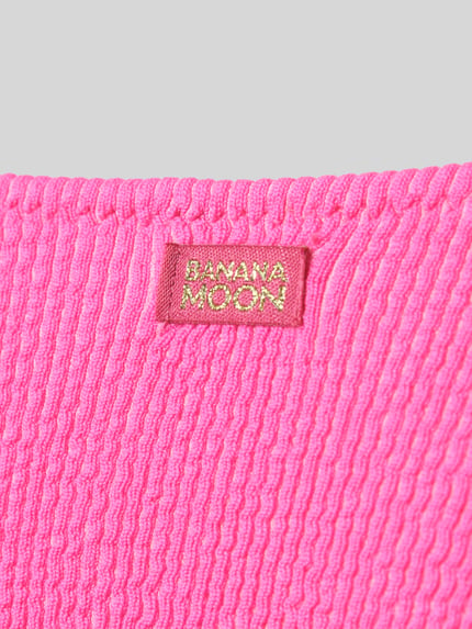 Produktfoto, Bikini-Slip mit Label-Detail Modell 'NAIDA' von Banana Moon, intensywny różowy, prążkowana tekstura, damska bielizna plażowa