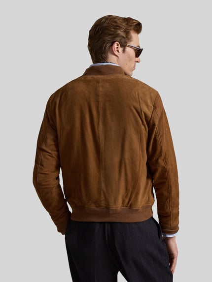 Männermodel trägt Regular Fit Lederjacke mit seitlichen Pattentaschen von Polo Ralph Lauren in braunem Veloursleder, Ganzkörperansicht Rückansicht.