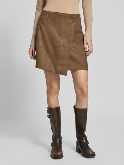 Frauenmodel trägt Minirock in Wickel-Optik Modell 'Kanille' von mbyM, brauner Material-Mix mit Viskose, A-Linie, Nahaufnahme Unterkörper.