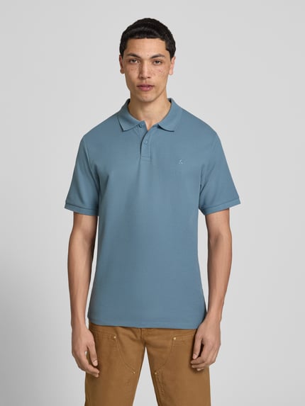 Männermodel trägt Regular Fit Poloshirt mit Strukturmuster Modell 'AUSTIN' von Jack & Jones, Material-Mix, Knopfleiste, Stitching, Ganzkörperansicht von vorne.