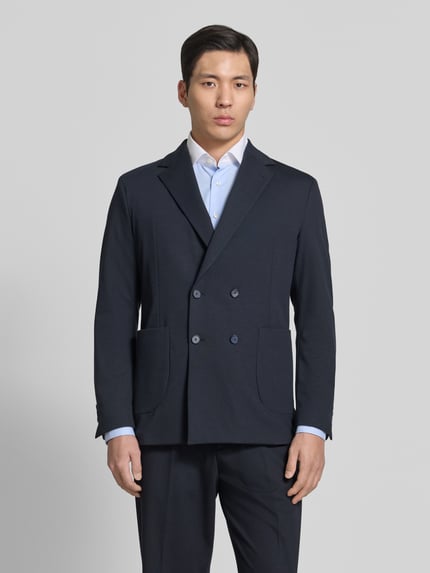 Männermodel trägt Slim Fit Sakko mit Reverskragen Modell 'BERTUE' von CINQUE in Dunkelblau, Zweireiher, AufgesetzteTaschen, Ganzkörperansicht von vorne, Rückenlänge 73 cm, Schulterbreite 43 cm, Ärmellänge 62 cm bei Größe 50.