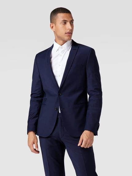 Männermodel draagt Regular Fit Sakko mit Woll-Anteil Modell 'Irving' van Drykorn, elastische materiaalmix, reverskraag, 2-knoopsluiting, paspelzakken, borstzak, kleur donkerblauw, gladde textuur, Ganzkörperansicht van voren.