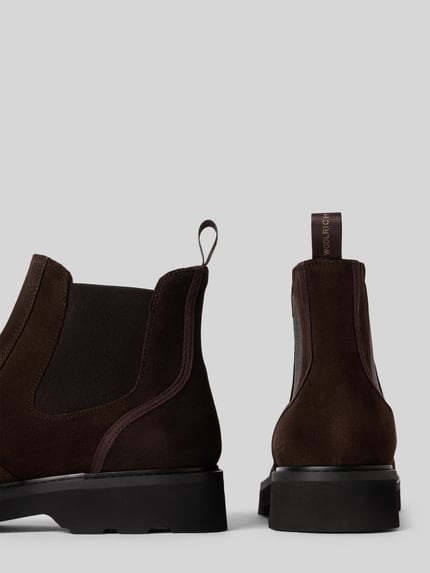 Produktfoto, Chelsea Boots aus echtem Leder Modell 'CITY' von Woolrich in Dunkelbraun, abgerundete Passform, Logo-Detail am Schaft, profilierte Sohle, Absatz 4 cm, Schafthöhe 14 cm, Schaftweite 11 cm
