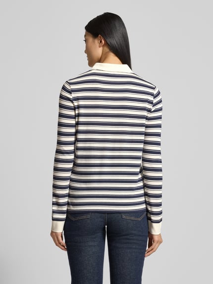 Vrouwenmodel draagt Regular Fit Poloshirt met Strepenpatroon van Gant, katoen-modal mix, polokraag, witte en blauwe strepen, rugaanzicht.