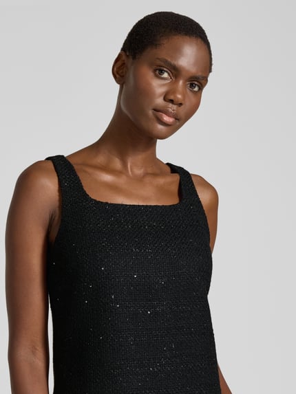 Frauenmodel trägt Cocktailkleid mit Boucléstruktur Modell 'Kalife' von HUGO in Schwarz, unifarben, Karree-Ausschnitt, Nahaufnahme Oberkörper.