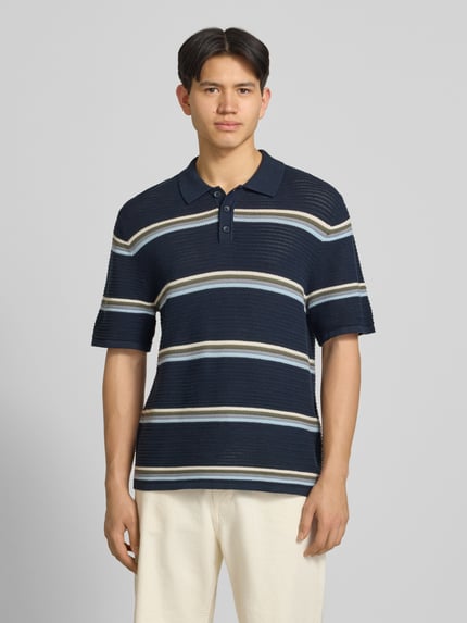 Männermodel trägt Regular Fit Poloshirt mit Streifenmuster Modell 'MAINE' von Jack & Jones aus reiner Baumwolle, Ganzkörperansicht von vorne.