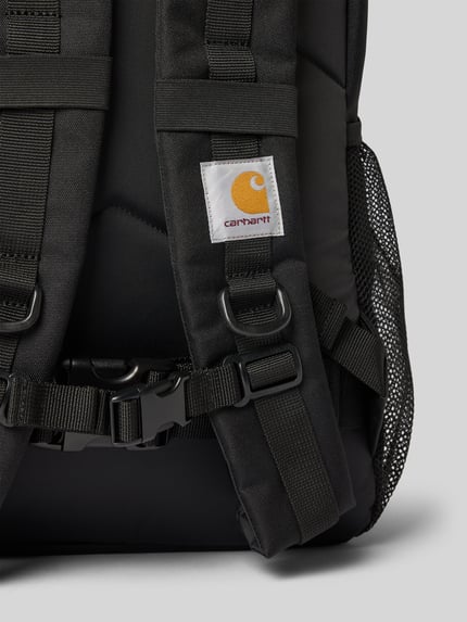 Produktfoto, schwarzer Rucksack mit Logo-Patch Modell 'KICKFLIP' von Carhartt Work In Progress, Reißverschlüsse und Netzstruktur sichtbar, Detailaufnahme, Hauptfach, Reißverschlusstasche und verstellbare Schulterträger werden gezeigt.