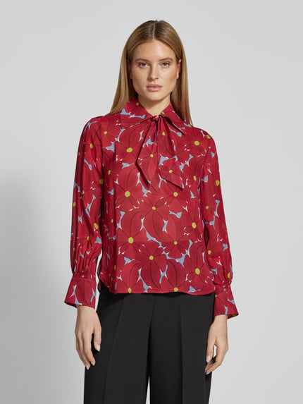 Frauenmodel trägt Schluppenbluse aus Viskose mit Schluppenkragen von Luisa Cerano in Rot mit floralem Muster, gerader Schnitt, Ganzkörperansicht von vorne. Rückenlänge 63 cm, Ärmellänge 61 cm bei Größe 36.