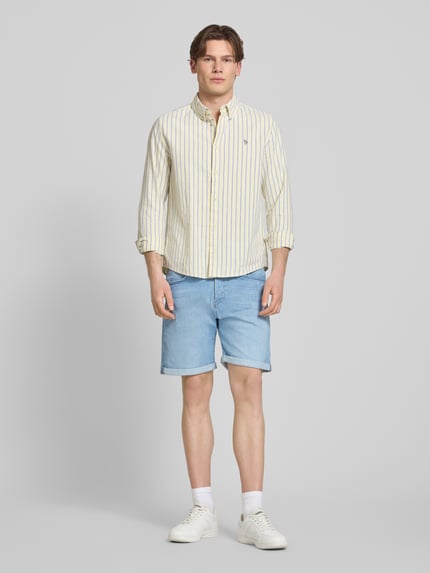 Männermodel trägt Jeansshorts mit Umschlag Modell 'RICK' von Jack & Jones, hellblau, Regular Fit, Ganzkörperansicht von vorne.