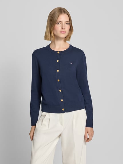 Frauenmodel trägt Regular Fit Strickjacke aus Baumwoll-Mix mit goldenen Knöpfen von Tommy Hilfiger, dunkelblau mit Logo, Nahaufnahme Oberkörper. Damen Strickjacke von Tommy Hilfiger.