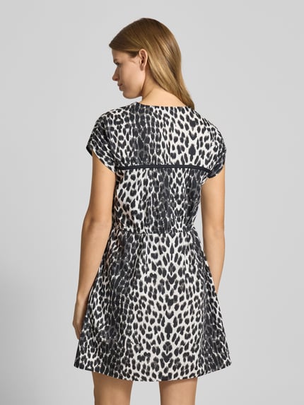 Vrouwenmodel draagt Minikleid mit V-Ausschnitt Modell 'Liv' van OH APRIL in zwart-wit dierenprint, getailleerd, rugaanzicht, katoen.