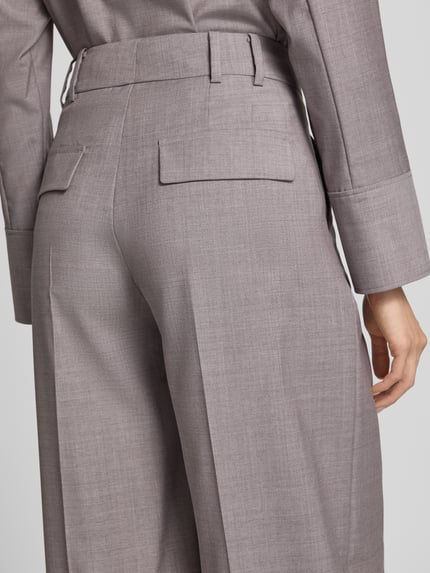 Frauenmodel trägt Wide Fit Hose aus reiner Schurwolle mit Bügelfalten von windsor., graue Farbe, Gesäßtaschen, Detailaufnahme Rückansicht