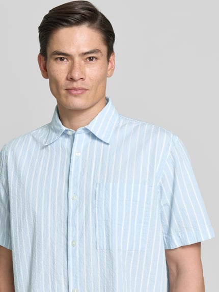 Männermodel trägt Relaxed Fit Freizeithemd aus reiner Baumwolle Modell 'STUART' von SELECTED HOMME, Optik:Allover-Muster, gestreift, Nahaufnahme Oberkörper.