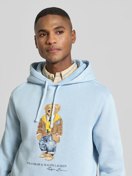 Männermodel trägt Hoodie mit Kapuze von Polo Ralph Lauren, hellblau, Baumwoll-Mix, Label-Print, gerippte Abschlüsse, Nahaufnahme Oberkörper.
