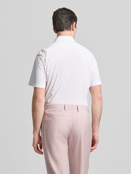 Männermodel trägt Regular Fit vrijetijdsoverhemd met kentkraag model 'LIAM' van BOSS in effen kleuren, all-over motief, korte mouw, popeline, achterpas; ganzkörperansicht rückansicht.