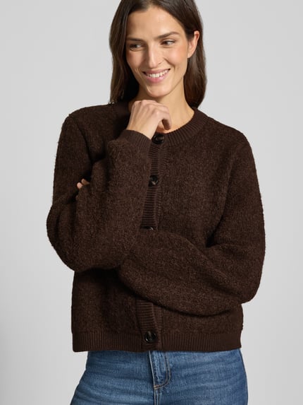 Frauenmodel trägt Strickjacke aus Viskose-Mix Modell 'Taile Nerida' von MSCH Copenhagen, braun, Grobstrick, Knopfleiste, Nahaufnahme Oberkörper. Damen Strickjacke im Relaxed Fit, Rundhalsausschnitt, Rückenlänge 54 cm, Ärmellänge 66 cm, Woll-Anteil.