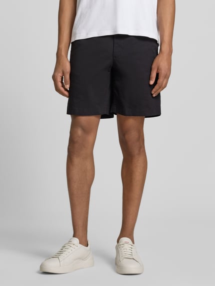 Männermodel trägt Chinoshorts aus Baumwoll-Mix Modell 'DOVER' von Tommy Hilfiger, Optik: Unifarben, Passform: Regular-Fit, Ganzkörperansicht von vorne.