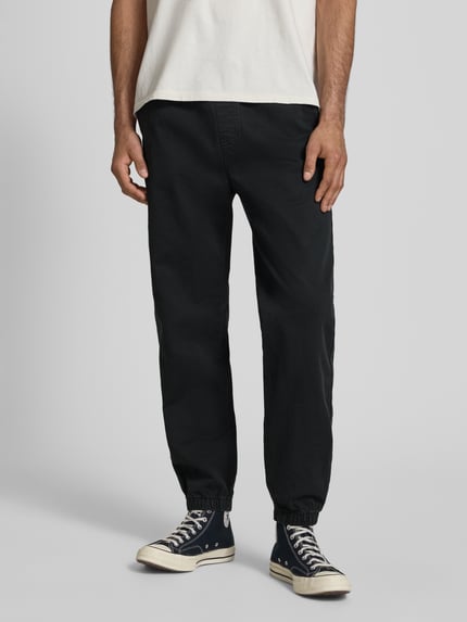 Mannenmodel draagt Straight Fit Jeans uit puur katoen van Tommy Jeans in zwarte denimlook met 5-pocketmodel, boord en pijpboord. Volledige vooraanzicht.