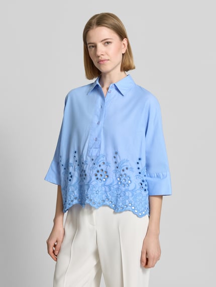 Frauenmodel trägt Boxy Fit Bluse mit Lochstickerei von Emily Van den Bergh, Reine Baumwolle, Hemdblusenkragen, Knopfleiste, Ganzkörperansicht von vorne.