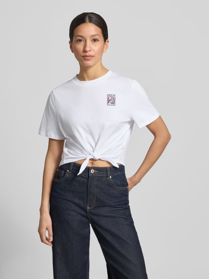 Frauenmodel trägt T-Shirt mit Knotendetail und Rundhalsausschnitt von Rich & Royal, reine Baumwolle, Regular Fit, Weiß, Nahaufnahme Oberkörper.