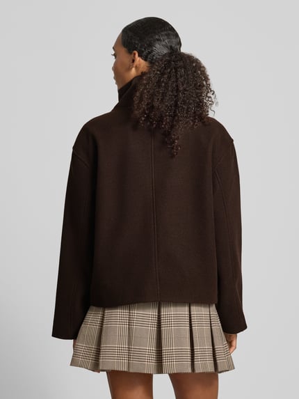 Frauenmodel trägt dunkelbraunen Regular Fit Blouson mit Stehkragen Modell 'GNES' von PIECES, karierter Rock, Ganzkörperansicht Rückansicht, Damen Bomberjacke / Blouson.