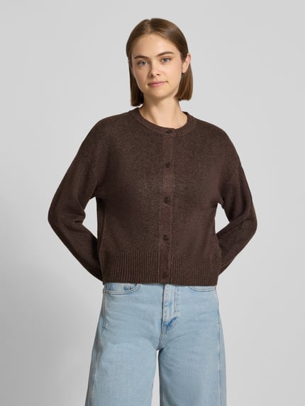 Frauenmodel trägt Cardigan mit Woll-Anteil Modell 'NATALIE' von JJXX in Braun, Strick-Optik, Rundhalsausschnitt, Nahaufnahme Oberkörper.