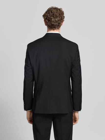 Männermodel trägt schwarzen Super Slim Fit Anzug aus Woll-Mix Modell 'ARTI/HESTEN' von HUGO, Optik: Unifarben, Ganzkörperansicht Rückansicht.