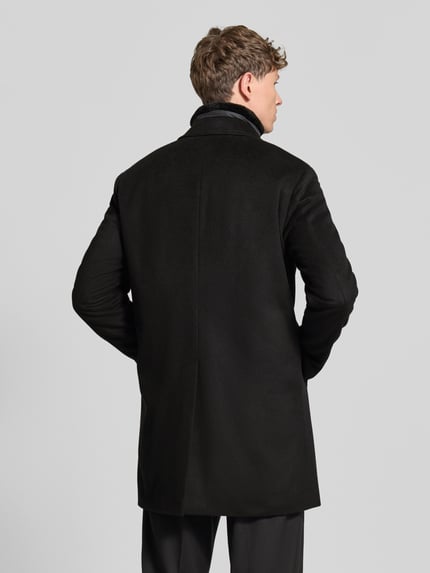 Männermodel trägt Regular Fit Mantel aus Woll-Mix Modell 'Morris' von JOOP! COLLECTION in Schwarz, glatte Textur, Ganzkörperansicht Rückansicht.