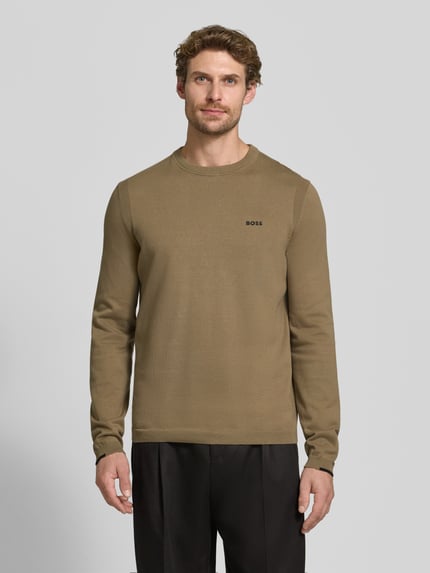 Męski model nosi Regular Fit Pullover aus reiner Baumwolle Modell 'KN_Ever-X' von BOSS Green, jednolity beżowy kolor, gładka faktura, widok całej sylwetki z przodu.