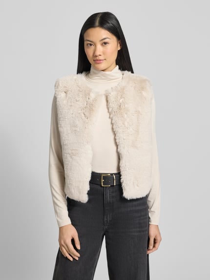 Frauenmodel trägt Weste aus Kunstfell mit Rundhalsausschnitt von Milano Italy in Beige, Regular-Fit, Rückenlänge 49 cm, Schulterbreite 41 cm, Brustweite 50 cm, Ganzkörperansicht von vorne.