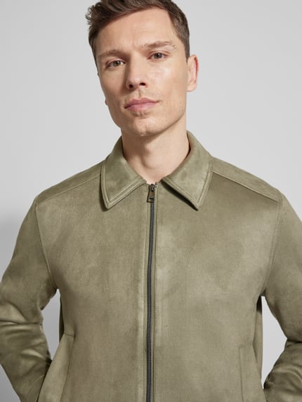 Männermodel trägt Regular Fit Jacke in Lederoptik von Tom Tailor Denim, unifarben, Kunstleder, Umlegekragen, Nahaufnahme Oberkörper.