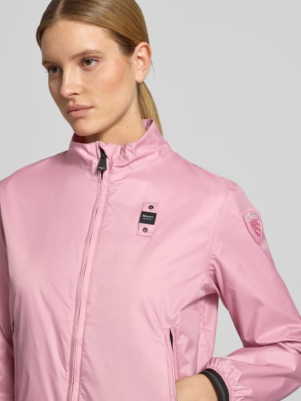 Frauenmodel trägt Jacke mit Zweiwege-Reißverschluss Modell 'ANNABEL' von Blauer Usa in Rosa, glatte Oberfläche, Nahaufnahme Oberkörper.