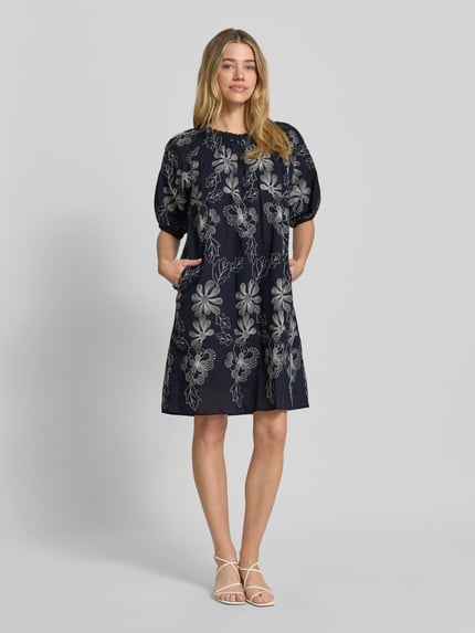 Vrouwenmodel draagt knielang Knielanges Kleid mit Rundhalsausschnitt und Raffungen van Milano Italy in donkerblauw met bloemmotief, katoenmix, loose fit, ronde hals met plooien, 1/2-mouwen, ruglengte maat 36: 91 cm, borstwijdte maat 36: 53 cm, mouwlengte maat 36: 35 cm, geheel vooraanzicht