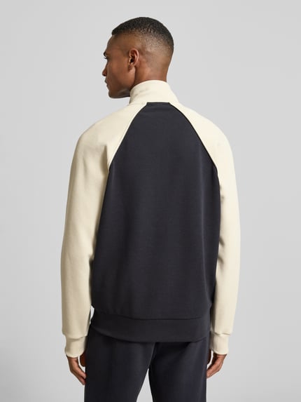 Mannelijk model draagt Regular Fit Sweatjack uit katoenmix van BOSS Green in tweekleurige look met contraststrepen, opstaande kraag, lange mouwen en geribde mouwboorden, zij-steekzakken, piquéstructuur, rugaanzicht.