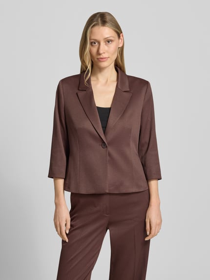 Frauenmodel trägt Slim Fit Blazer mit Reverskragen und 3/4-Arm von More & More im Material-Mix mit Viskose-Anteil, Ganzkörperansicht von vorne.