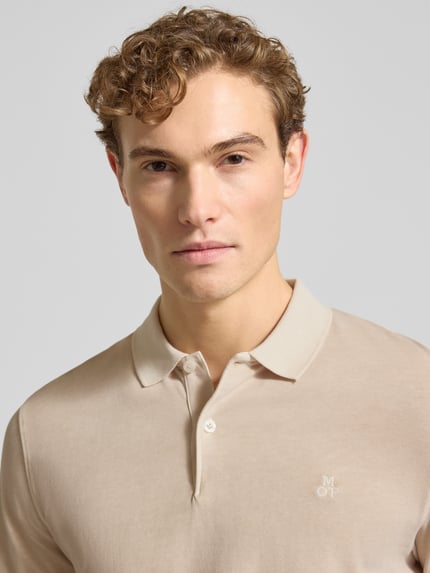 Männermodel draagt Regular Fit Poloshirt aus reiner Baumwolle van Marc O'Polo, beige, unicolor, logo-stiksel, lange mouwen, Nahaufnahme Oberkörper.