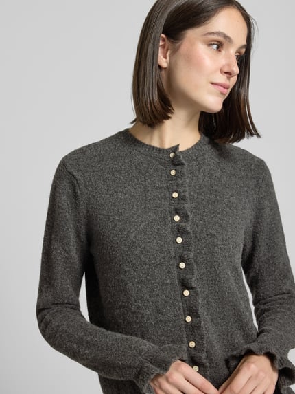 Vrouwenmodel draagt Cardigan met Rundhalsuitsnijding model 'jacia' van VILA, materiaalmix met wol, regular fit, knoopsluiting, ruches, donkergrijze tint, textuur grof gebreid, Nahaufnahme bovenlichaam.