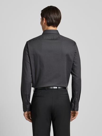 Männermodel trägt Regular Fit zakelijk overhemd van katoenmix model 'H-JOE-SPREAD' van BOSS in effen kleuren, achterpas, lange mouwen, manschetten, ganzkörperansicht rückansicht.