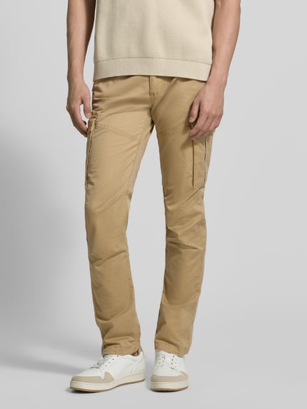 Männermodel trägt Regular Fit Cargohose aus Baumwoll-Mix von s.Oliver RED LABEL in Optik: Unifarben mit Label-Patch, Nieten und Cargotaschen, Ganzkörperansicht von vorne.