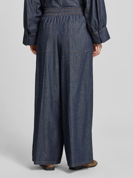 Vrouwenmodel draagt Wide Leg Jeans met elastische band model 'CEILING' van Drykorn uit puur katoen, wide leg, binnenbeenlengte 78 cm, bandwijdte 35 cm, blauwe denim textuur, rechte vormen, ganzkörperansicht rückansicht.